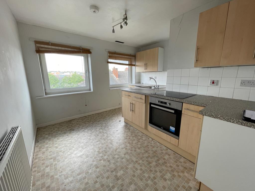 Lot: 21 - TWO-BEDROOM FIRST FLOOR MAISONETTE FOR REPAIR AND IMPROVEMENT - fitted kitchen with windows to the front